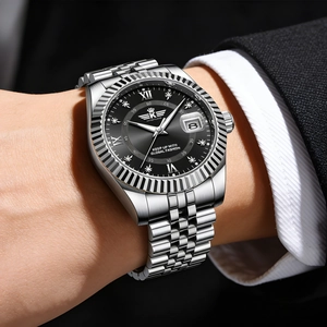 Detailed close-up of a silver men's watch with black dial and Roman numeral indices