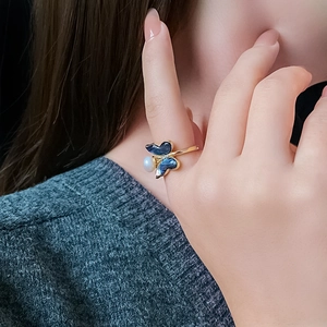 Detail of gold-plated butterfly ring with blue enamel and a lustrous freshwater pearl
