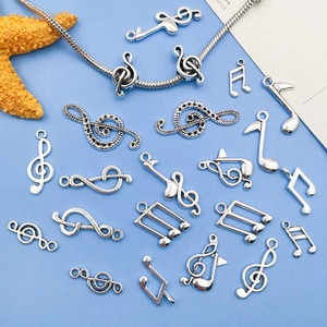 Silver musical note pendants including treble clefs for DIY jewelry making on blue background