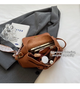 Detailed view of brown lychee leather crossbody bag interior with multiple compartments