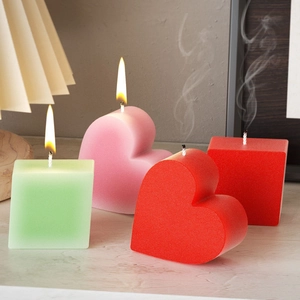 Artistic set of heart and cube shaped candles with a matte finish in a warm room setting