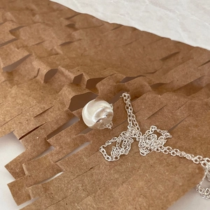 Minimalist 925 sterling silver beaded necklace with brushed sphere pendant on craft paper