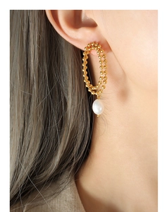 Close-up of gold double hoop earrings featuring elegant white teardrop freshwater pearls
