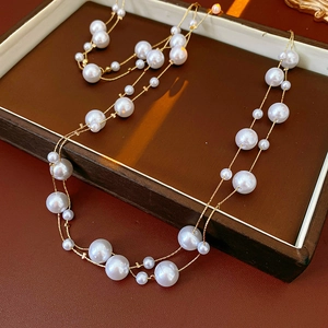 Detailaufnahme einer Vintage-Perlenkette mit goldener Kette in einer Schmuckschatulle