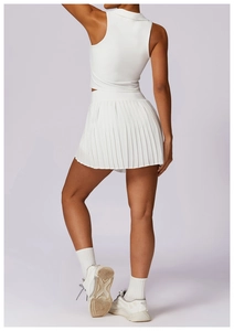 Side view of white sleeveless polo crop top and pleated tennis skirt set on a model