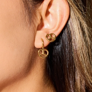 Close-up of a model wearing golden geometric hollow round earrings with polished finish