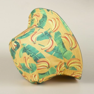 Detail of yellow cotton bucket hat with tropical banana and green leaf print