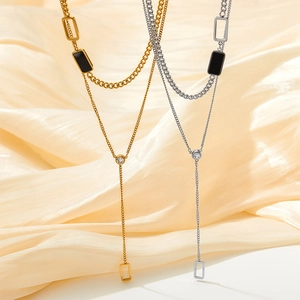 Elegant double layer Y-shaped necklace with gold and silver square pendants on silk background