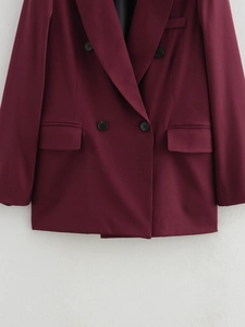 Dettaglio del blazer doppiopetto bordeaux che mostra la trama e i revers formali