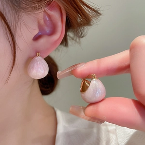 Detailed view of pink teardrop earrings with a glossy pearlescent finish and gold metal clasp