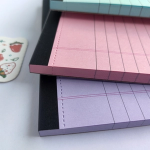 Minimalist A5 notepad with colorful pages and black fabric spine, stacked view