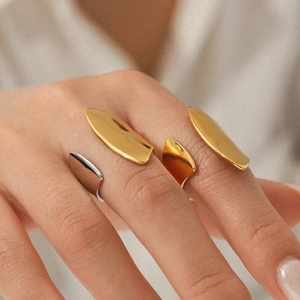 Detailed view of minimalist gold and silver organic shape open rings on a hand