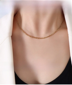 Close-up of a 2.1mm golden square double link chain necklace worn on a model