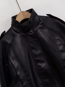 Gros plan sur la veste en cuir noir texturé avec col montant et détails d'épaulettes