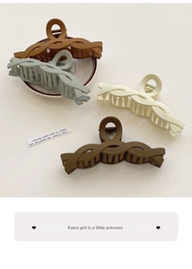 Detail view of four matte hair clips in coffee, cream, olive, and brown twisted designs
