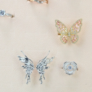 Macro view of crystal butterfly rings with fine micro-pavé diamonds on jewelry display