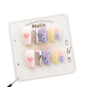 Handmade press-on nails with mixed pink hearts, blue dots, and yellow gradient designs