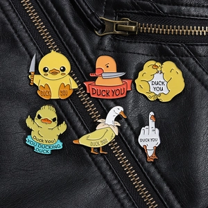 Macro detail of quirky yellow duck enamel pins with humorous designs on leather jacket