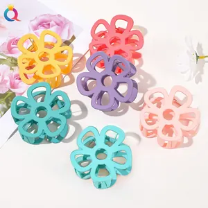 Flat lay of six matte floral hair claws in vibrant colors for elegant hair styling