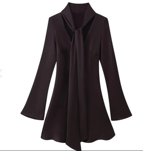 Detail of dark brown satin dress featuring V-neckline with scarf tie and flared cuffs