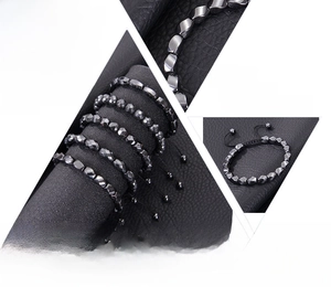 Macro detail of irregular black hematite magnetic stone beads and woven bracelet textures