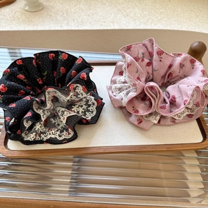 Détail de chouchous à fleurs avec bordure en dentelle rose et noire sur plateau