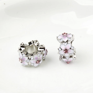 Detail of silver alloy beads with pink enamel flowers and rhinestones for DIY bracelets