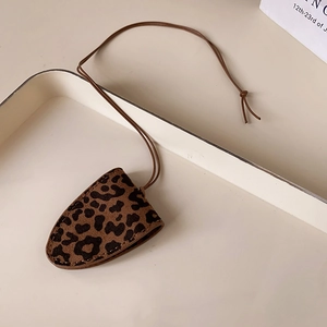 Close-up of leopard print faux leather glasses case with detailed stitching and lanyard