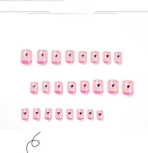 Vue détaillée des faux ongles roses translucides avec motifs minimalistes de cœurs noirs
