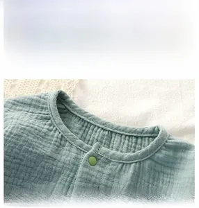 Detail of baby romper neckline made of light green breathable cotton muslin fabric