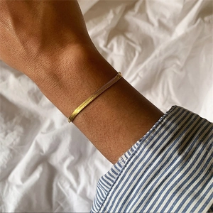 Elegant gold-plated flat snake chain bracelet worn on wrist for a minimalist style