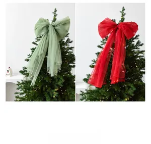Detail of sage green and red tulle Christmas bows with long ribbons on a tree