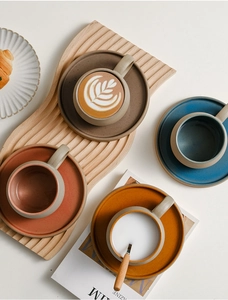 Vista dall'alto di tazze da caffè e piattini in ceramica vintage in vari colori
