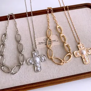 Vintage silver and gold cross necklaces with pearls on a linen display tray