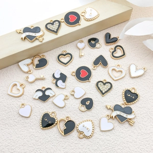 Detail of heart-shaped enamel charms with wings and Love engraving for DIY jewelry