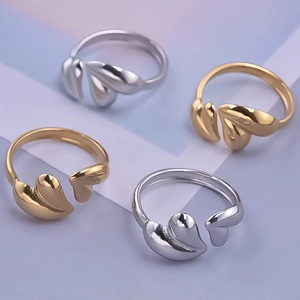 Detailed view of polished stainless steel heart rings in gold and silver finishes