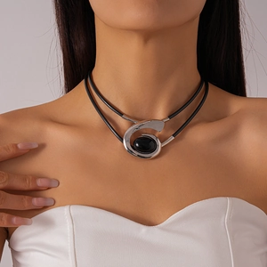 Vue détaillée d'un collier double épaisseur avec pendentif spirale argenté et pierre noire