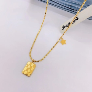 Detail of golden cylinder bead necklace with rectangular checkerboard pendant and star charm