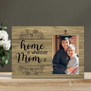 Close-up of wooden photo frame with clip and home is wherever Mom is printed design