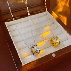 Dettaglio di collane con ciondolo a stella in oro e argento in una scatola beige di lusso