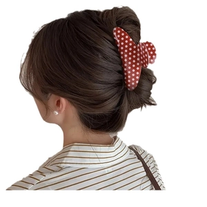 Polka dot PVC hair claw clip in red and white shown on model for high ponytail styling
