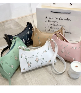Detailed overhead view of lace embroidery underarm bags in black, khaki, green, pink and white