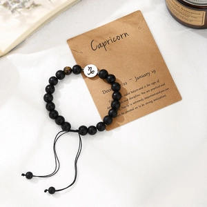 Detail of handmade Capricorn zodiac bead bracelet with tiger eye stone on display card