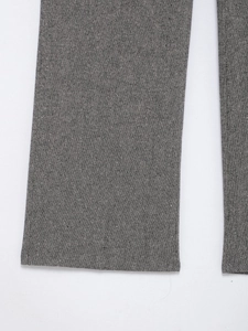 Detail shot of grey suit trousers leg showing premium fabric texture and neat stitching