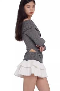 Detail of layered white pleated skirt with ruffled design and soft knit texture