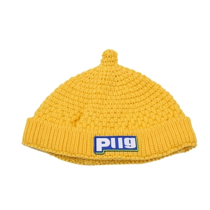 Detailed knit texture of a yellow baby beanie featuring a colorful PUG letter patch