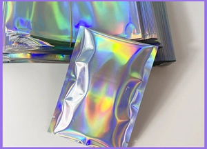 Detailed view of silver holographic self-sealing mailers showing rainbow laser reflections