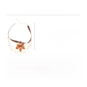 Macro shot of a leather choker necklace featuring a resin flower and tiger eye stone