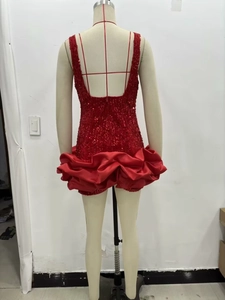 Détail de la robe mini à sequins rouges avec dos nu en V et ourlet en satin plissé