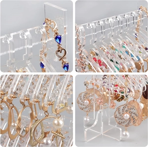 Detail view of transparent acrylic jewelry organizer with hangers for earrings and necklaces